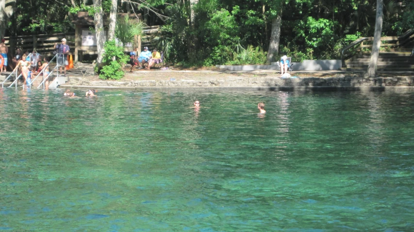 some people in swimming suit are by the edge of the water