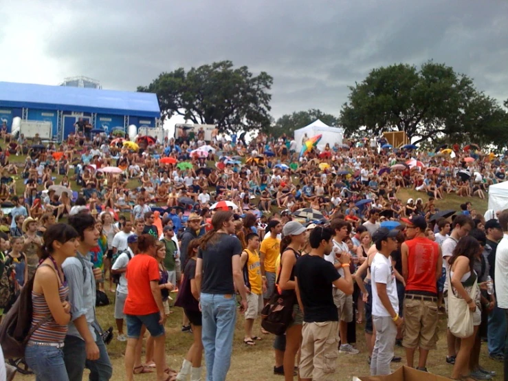 a crowd is gathered in a field with tents