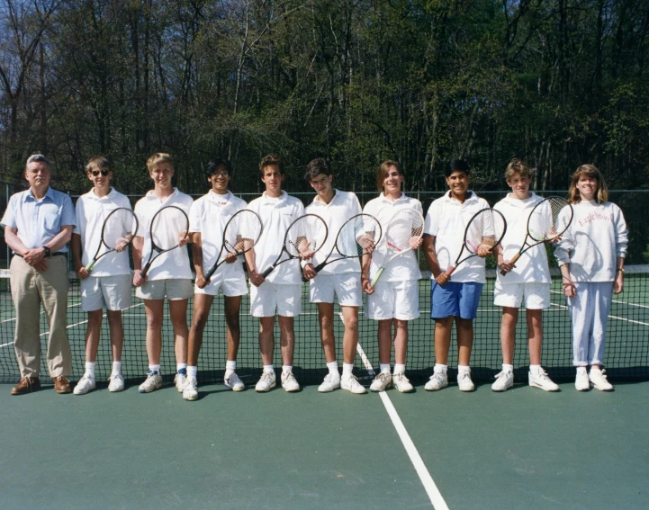 a group of young tennis players poses for a po