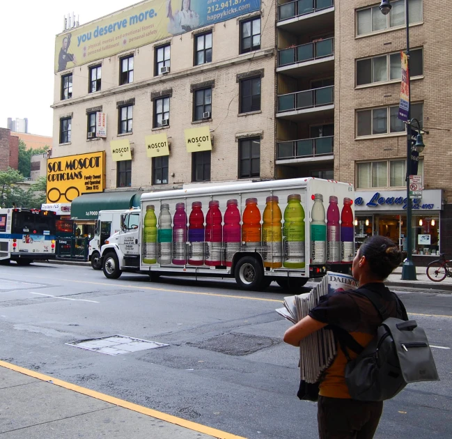 several different delivery vehicles drive down the street