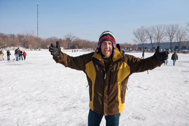 a man in the snow holding his thumbs up