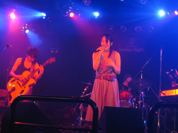 a group of people standing on stage singing and playing
