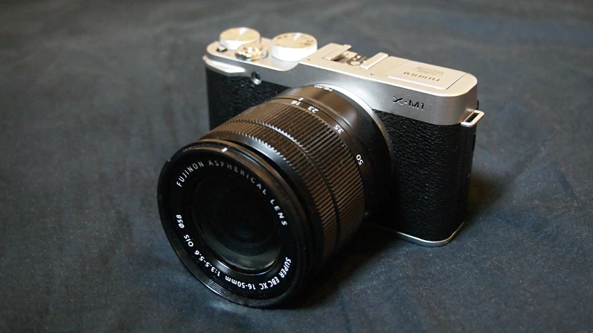 a silver and black camera on a blue table