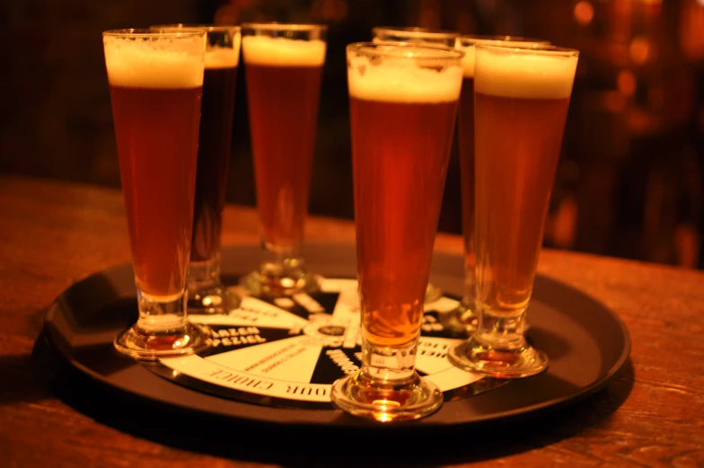 four glasses of light beer in a row on a coaster