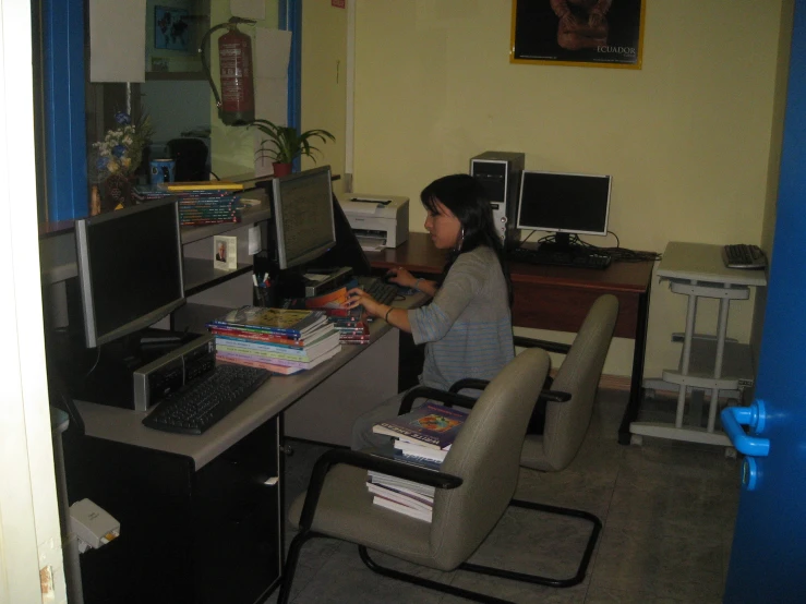a woman sitting in a chair working on a computer