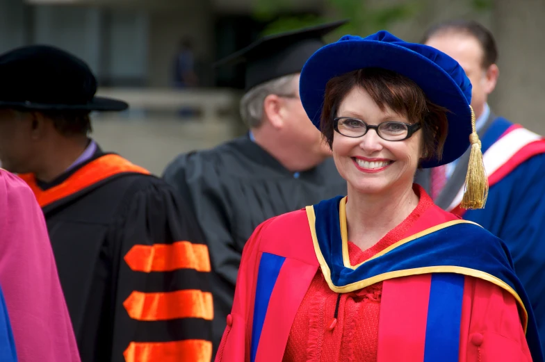 a woman in a blue and orange graduation gown