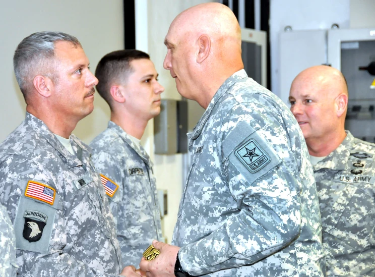 two men in military uniforms shaking hands next to each other