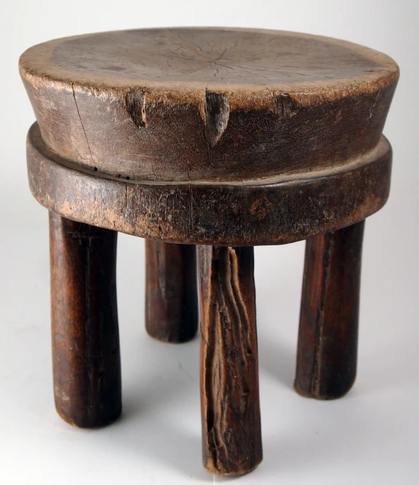 a wooden stool with three wooden sticks sticking out