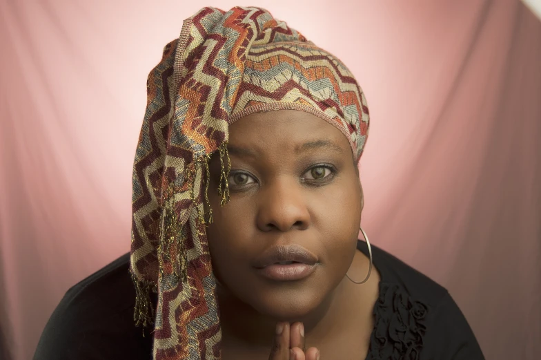 a woman wearing a red and brown head wrap