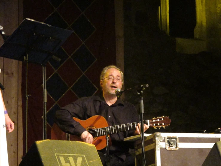 a man is singing and playing the guitar