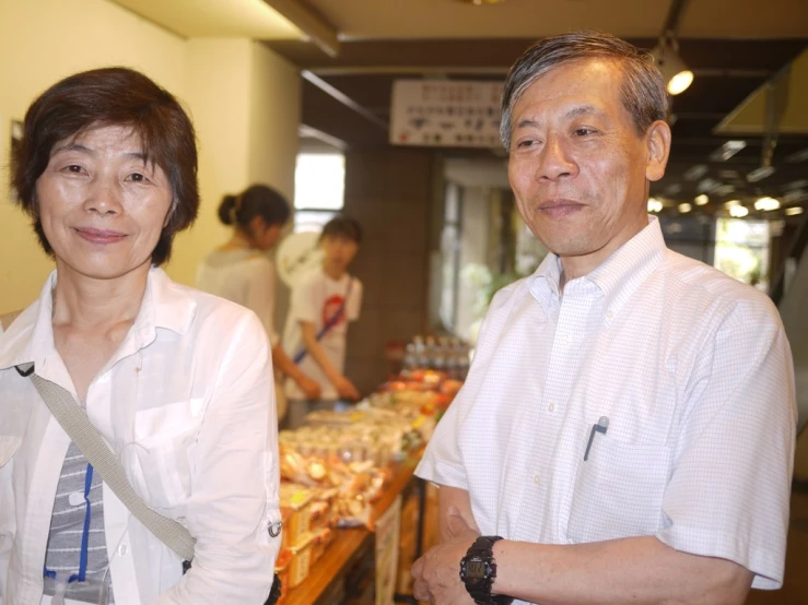 a couple standing in a room with various foods