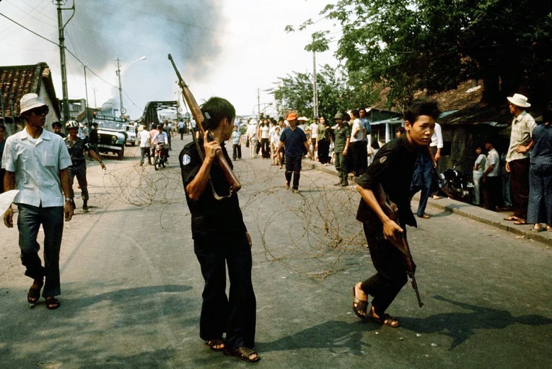 people are marching down a street holding guns