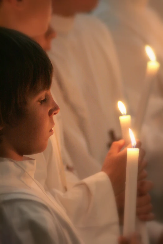 a  holding candles while wearing a white jacket