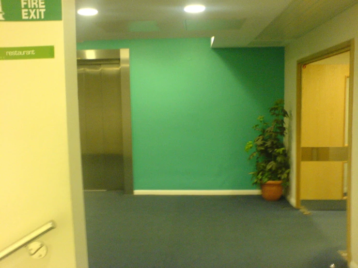 a green sign in an office space indicating exit