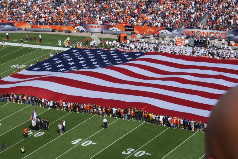 an american flag is laid out in the middle of a football field
