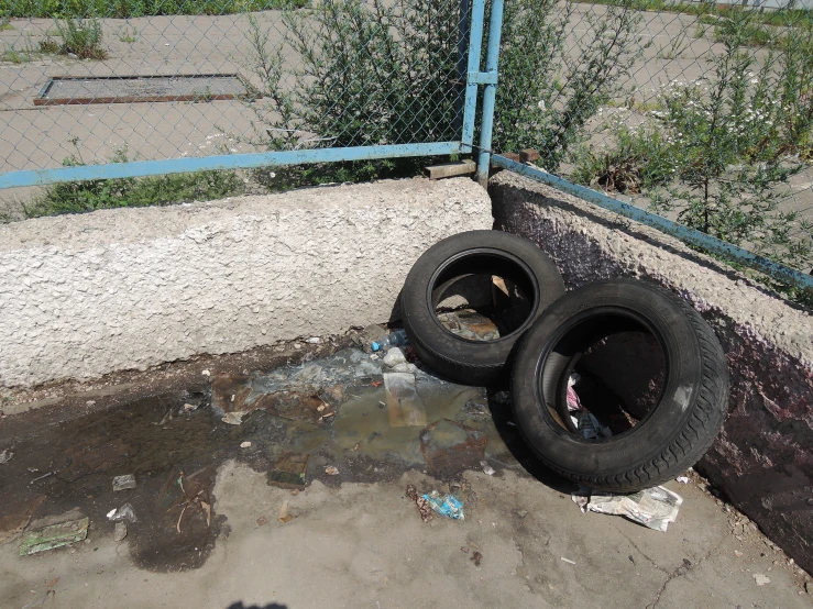 two tires that are leaning against the fence