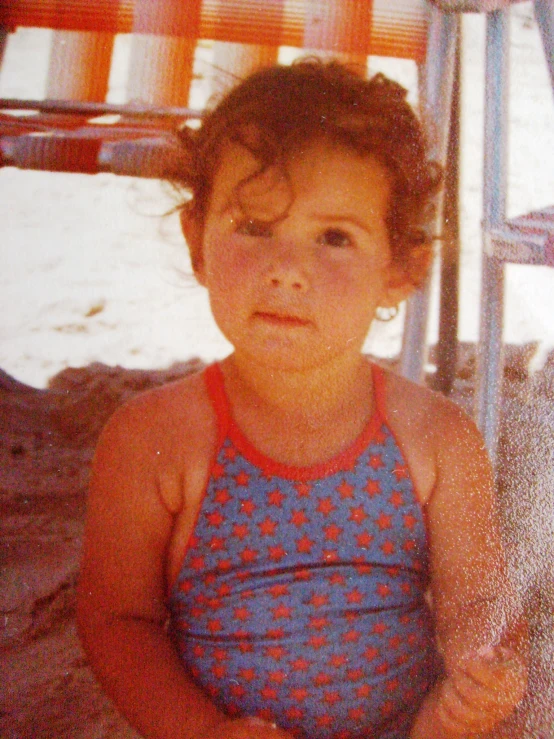 a child standing in the sand at a beach