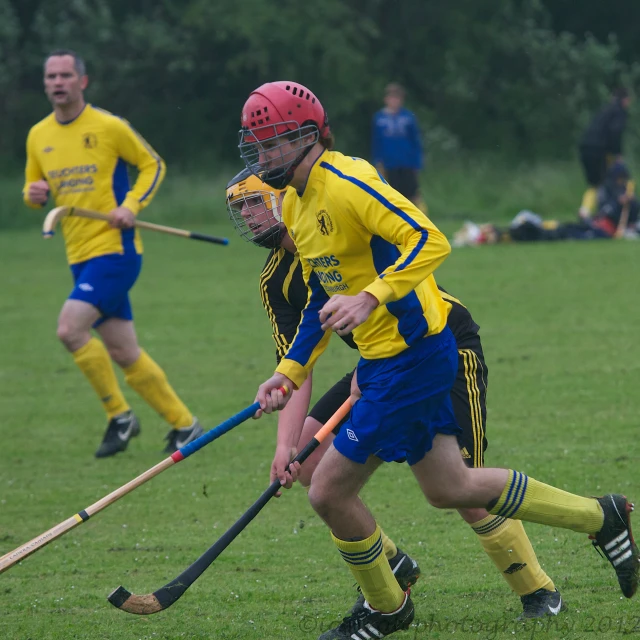 the young men are playing lacrosse on the field