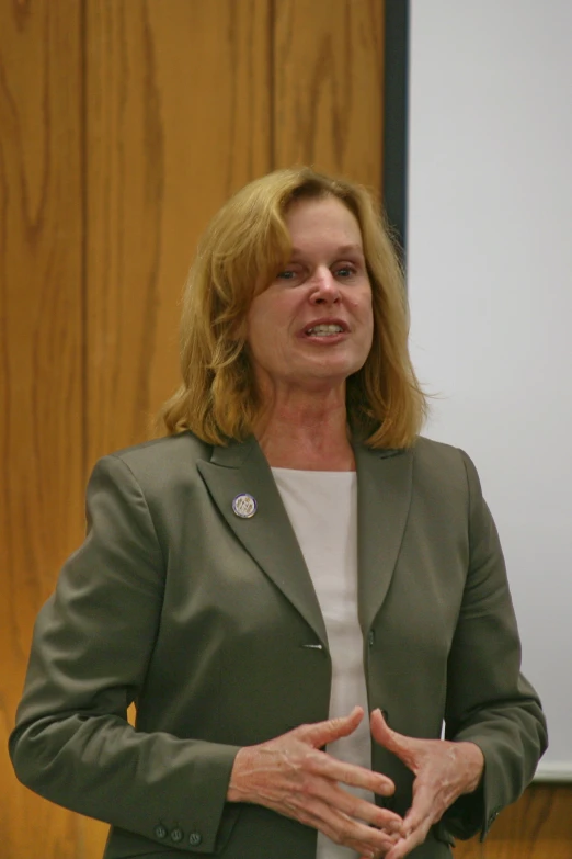 a woman talking into a microphone in front of a screen