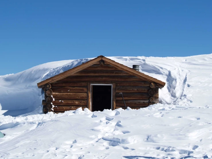 there is a small wooden building sitting in the snow