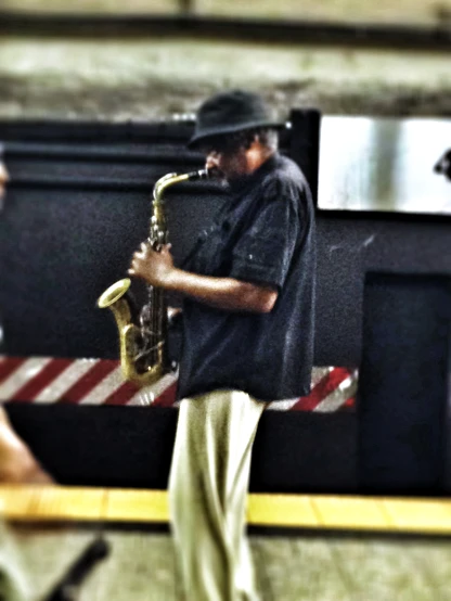 a man playing on a saxophone in a train station