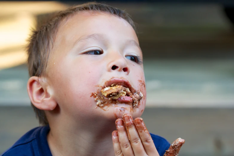 a boy is eating some food with his hands