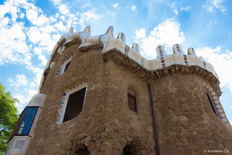 a castle like building is seen against a blue sky with clouds