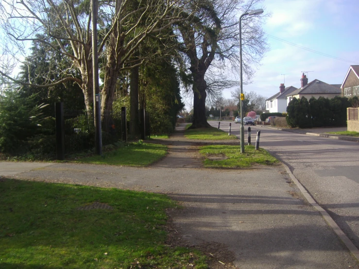 an empty road with cars parked along the side