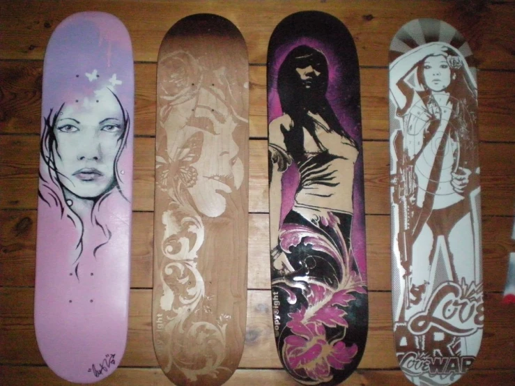 a few snowboards with the designs of some women on them