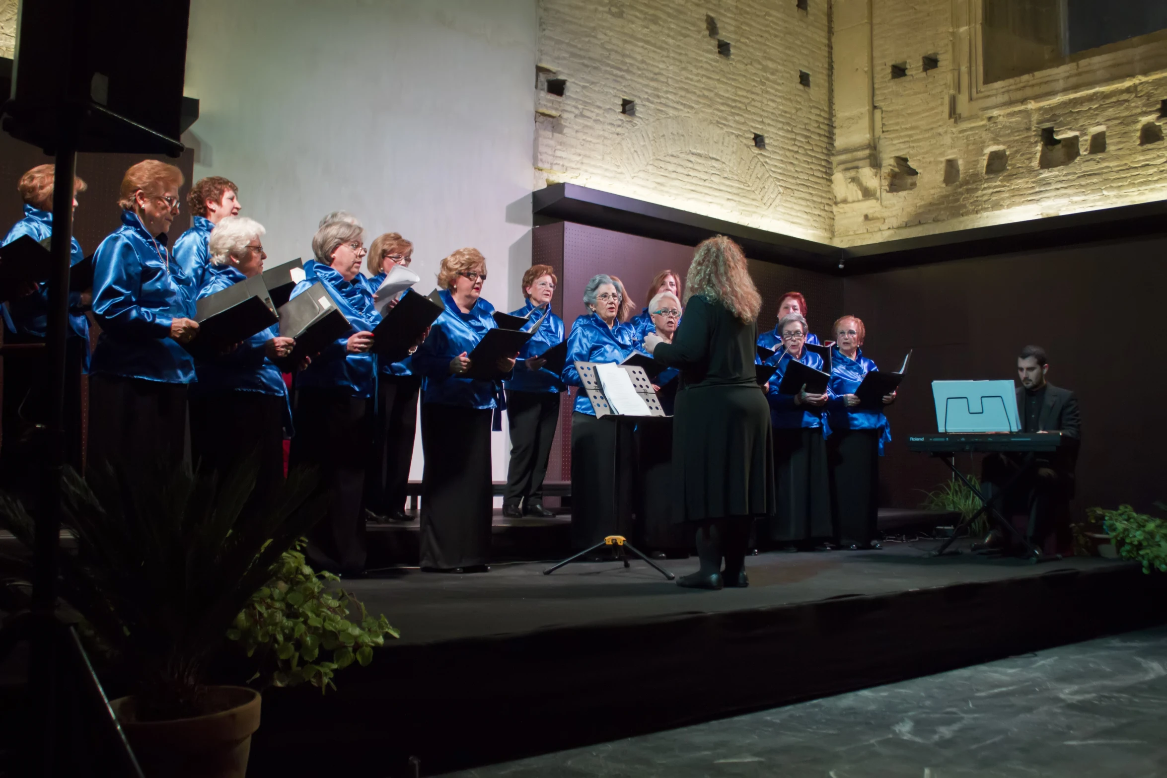 choir members are standing and singing for an audience