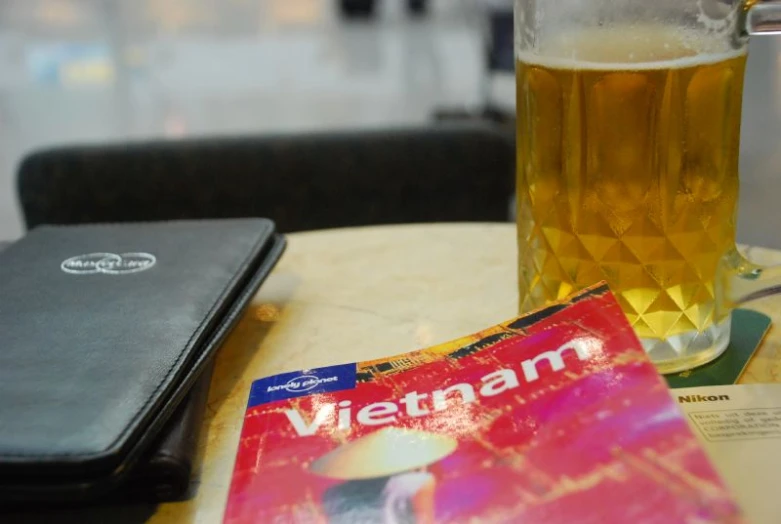 a beer and a book sit on a table