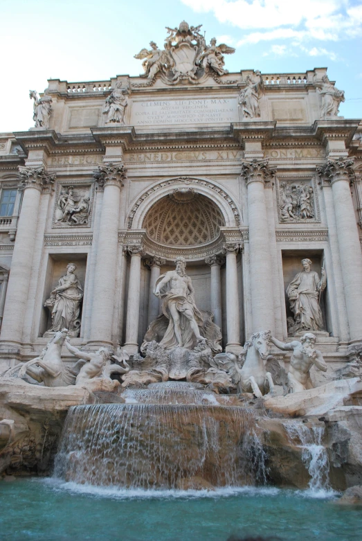 a water fountain sitting next to a building with a fountain in front of it