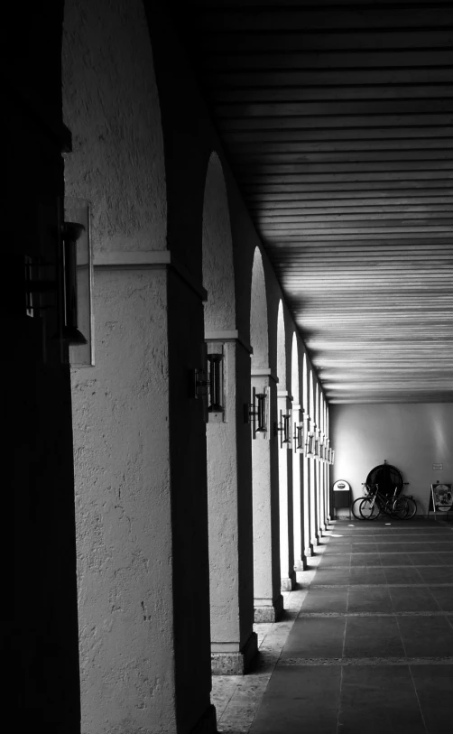 a row of archways in an alley with the light reflecting off the window