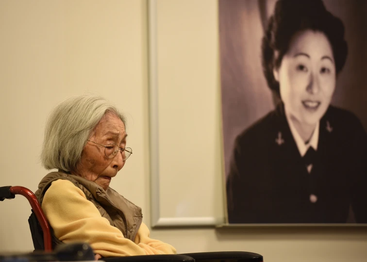 a woman sits in front of an image of a black woman