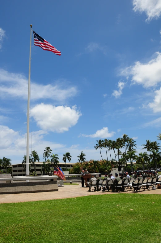 some people are watching an american flag fly