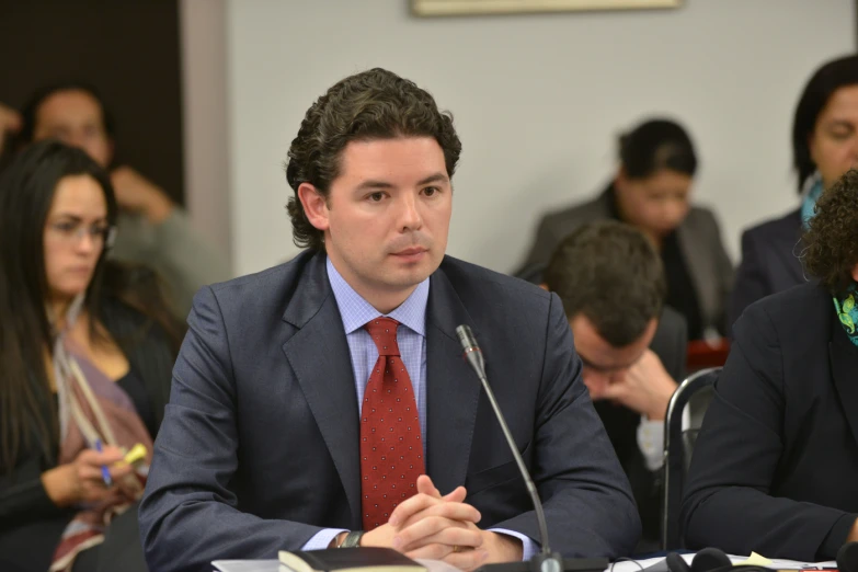 a man in suit and tie sitting at table