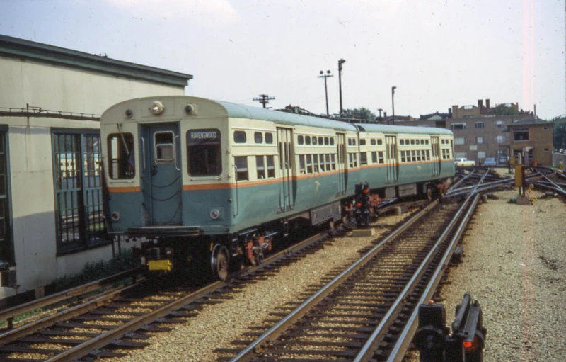 a train parked in front of a building and railroad tracks