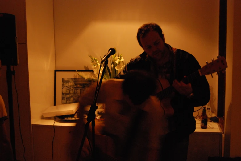 a man that is standing next to a guitar