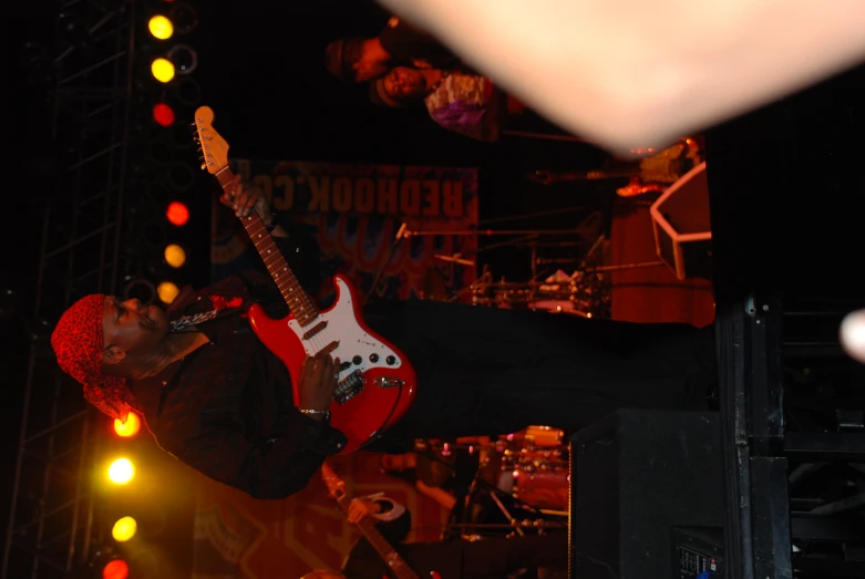 a man in black shirt playing an electric guitar