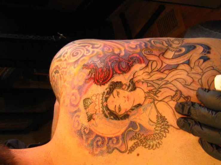 a man with tattoos is getting inked on his chest