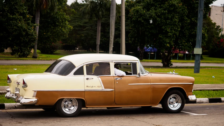 a classic car parked at an intersection during the day