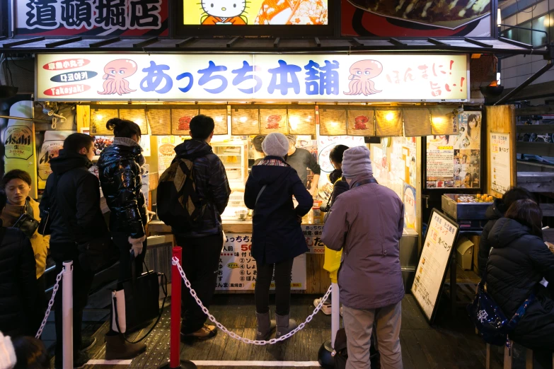 some people waiting in line at the food stand