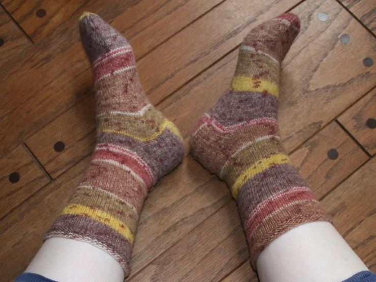 a person's feet in striped socks with their legs crossed