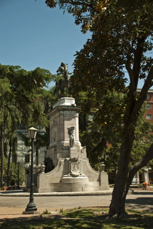 a statue is surrounded by trees in front of a building