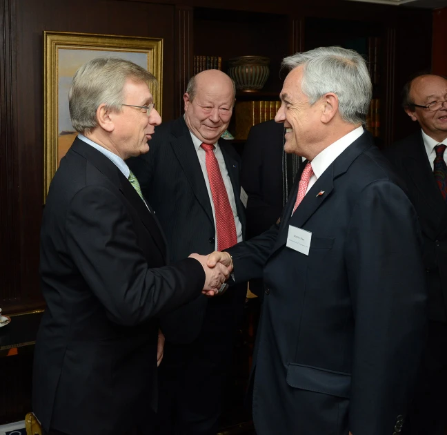 men are smiling at each other while shaking hands