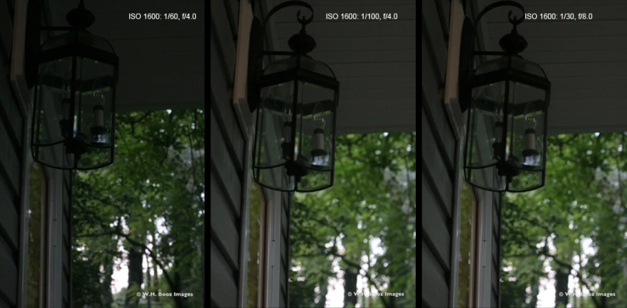 three lamps hanging from a ceiling outside of a building