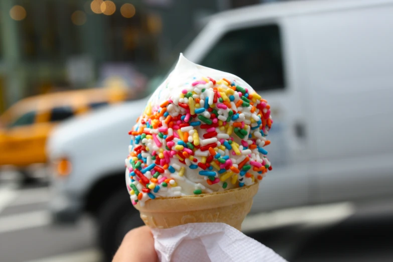 someone is eating a delicious cone of ice cream with sprinkles