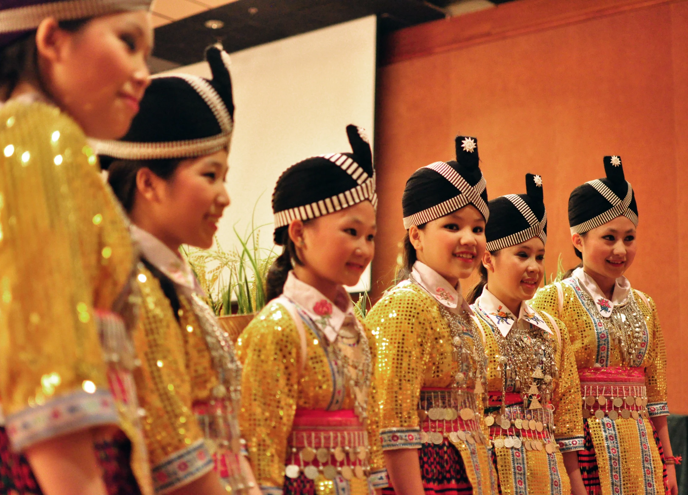 girls wearing colorful dresses and big hats standing together