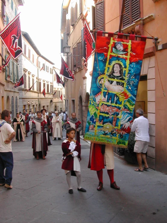 a little boy holding an art piece while a man in costume watches