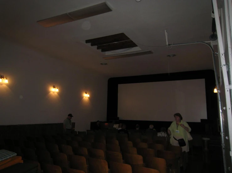 people are gathered around a projection screen in the movie theater
